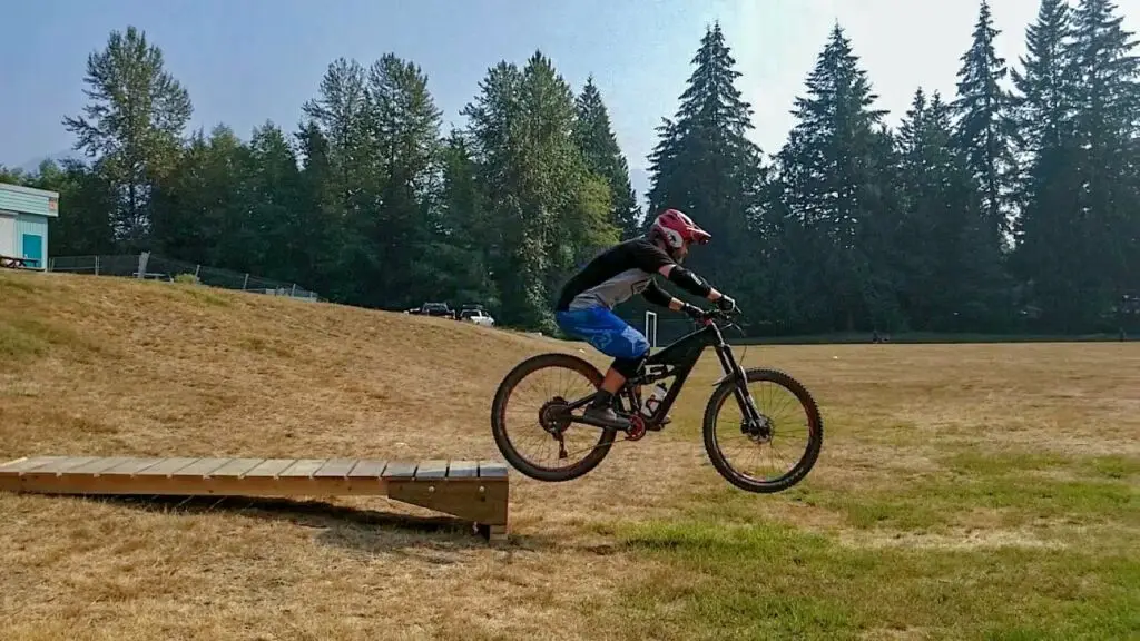 A person riding a mountain bike on an adventurous wooden ramp in Squamish