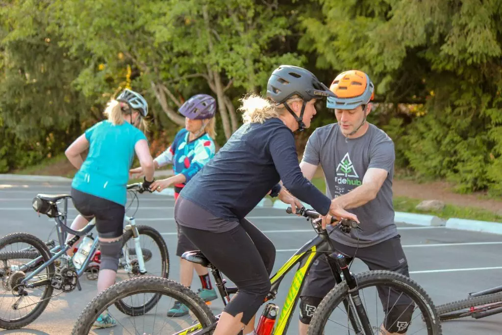 A group of people on an adventurous mountain biking expedition through a parking lot.