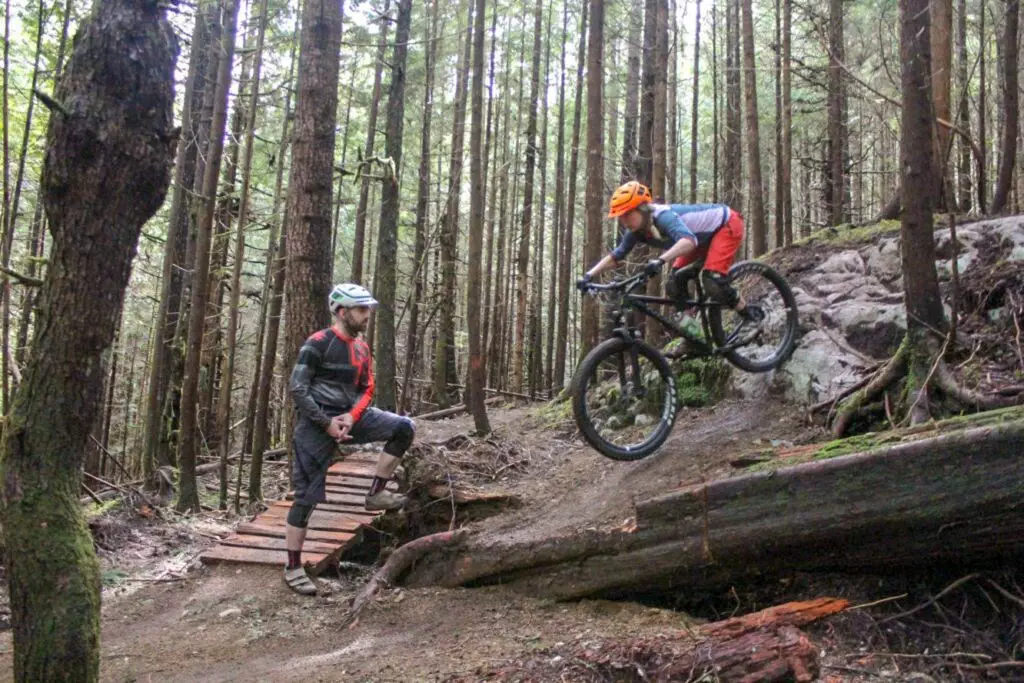 Two mountain bikers riding down a trail in Squamish.