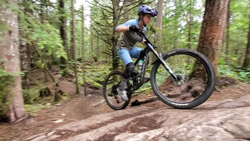 A rider going up a punchy section of trail in Squamish using the skills from our mountain bike climbing lessons